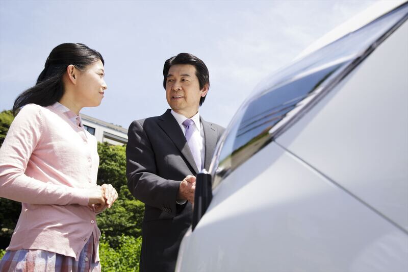 顧客に車を紹介するスタッフ